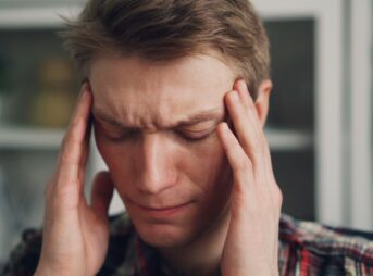 a man holding his hands to his ears