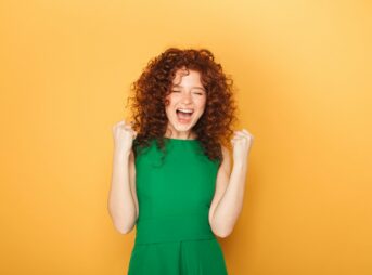 a woman in a green dress is laughing