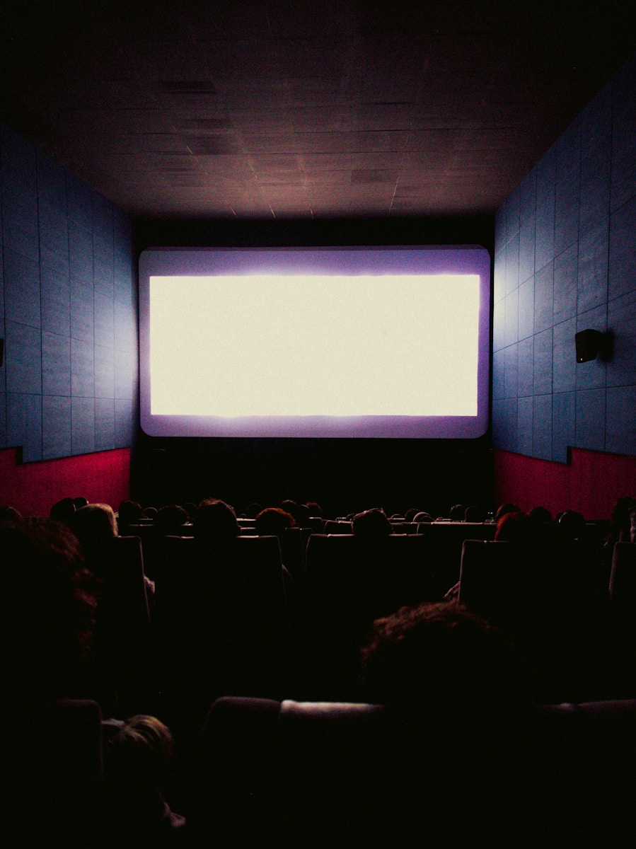 a large screen in a dark room with people watching it