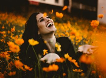 woman laughing on flower field